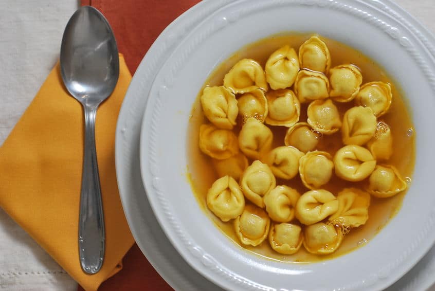 31767156 - tortellini soup in white plate