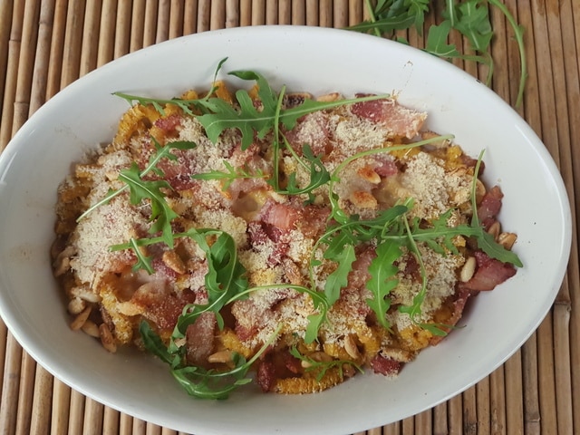 Baked passatelli with pancetta and pine nuts