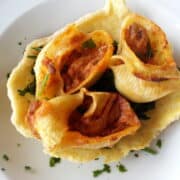 Stuffed lumaconi on a bed of spinach in a crispy cheese bowl