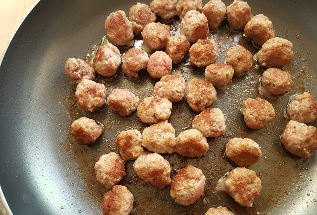 veal meatballs cooking in frying pan