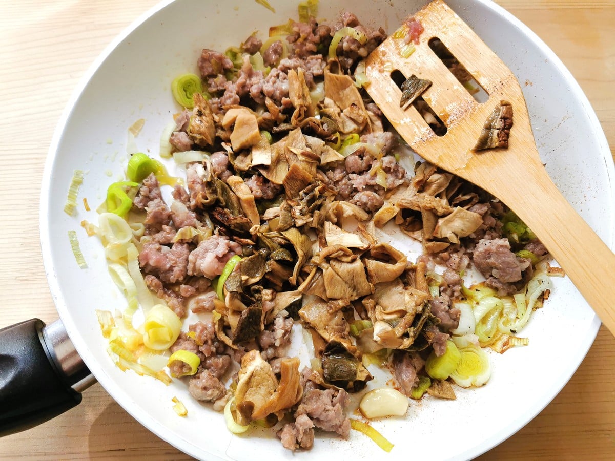 porcini mushrooms added to the sausage meat and leeks in frying pan