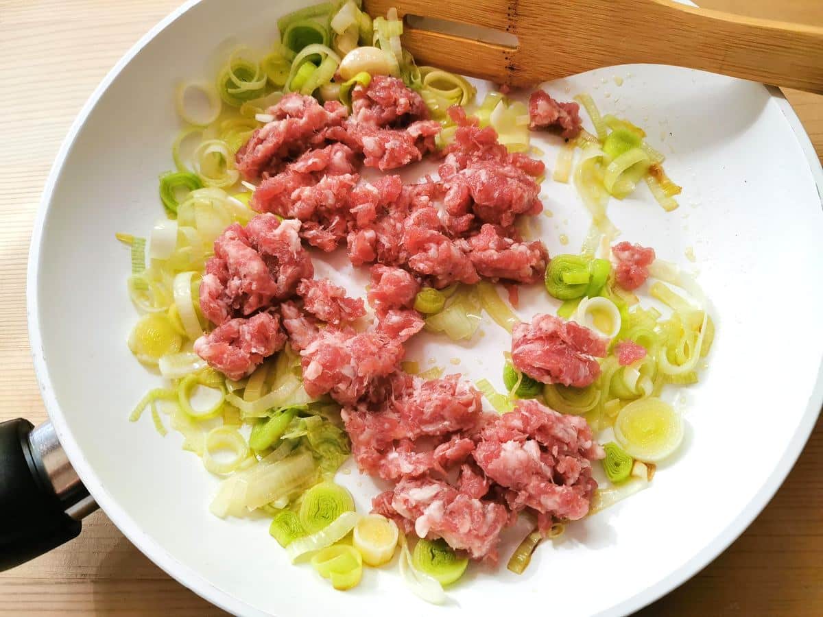 sausage meat in frying pan with leeks and garlic