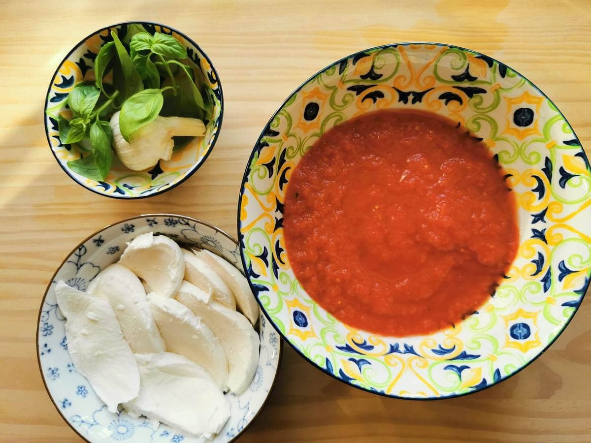 Ingredients for tomato sauce plus mozzarella slices for baking.