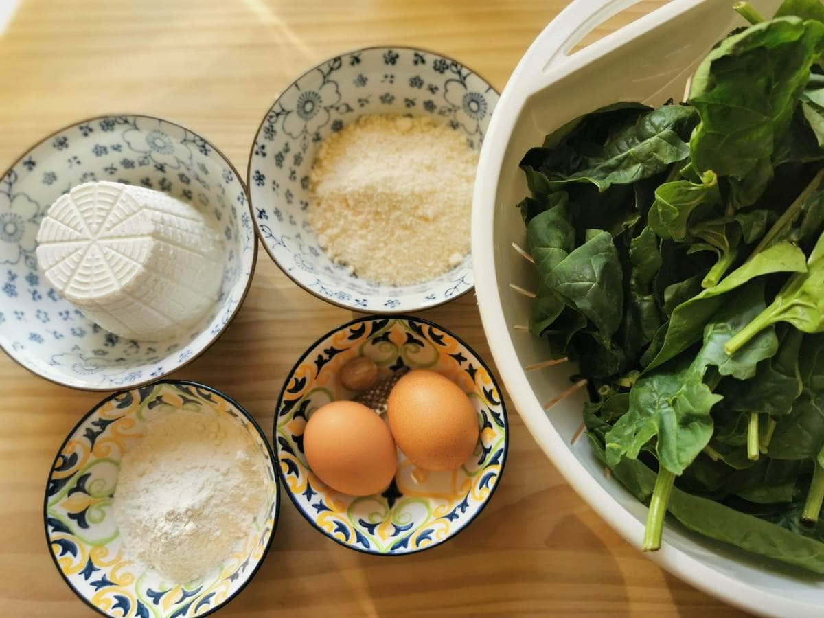 Ingredients for Tuscan gnudi on wood work surface.