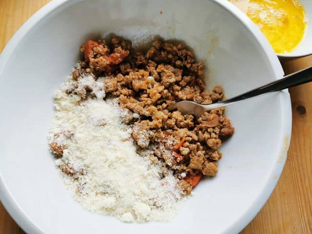 some of the ragu in a white bowl with grated pecorino and beaten egg in another white bowl