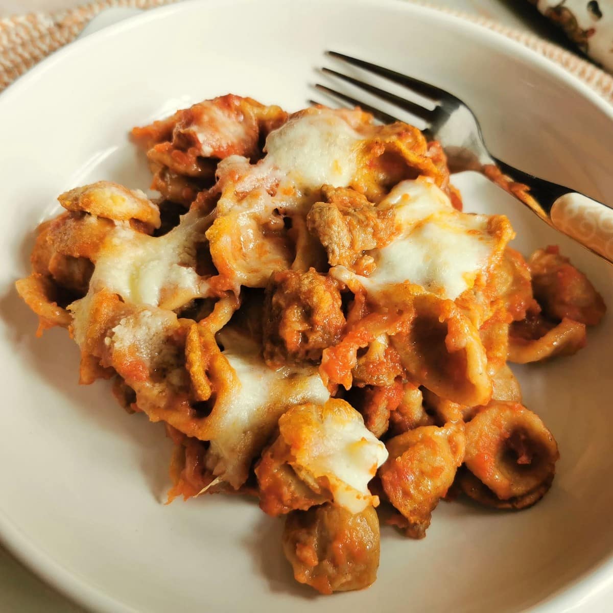 baked orecchiette with lamb in white bowl.