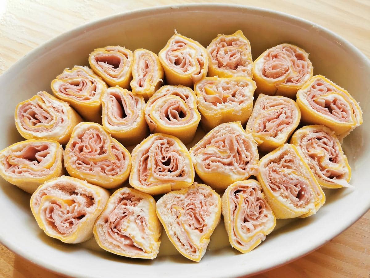 Uncooked pasta roses in white oval oven dish.