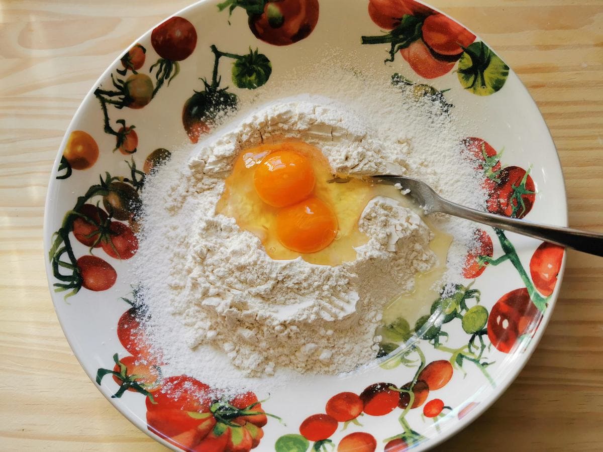 White flour in bowl with eggs.