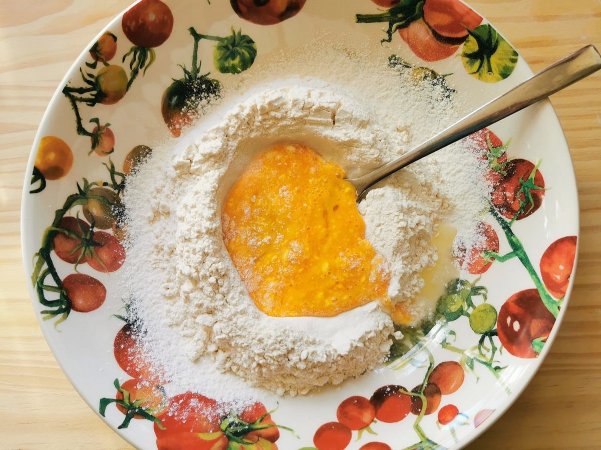 White flour in bowl with beaten eggs.