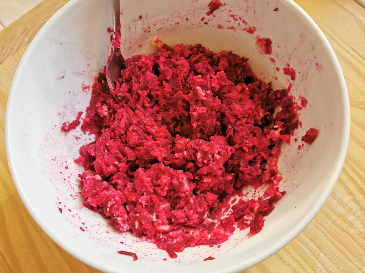 Ready beetroot and potato ravioli filling in white bowl.