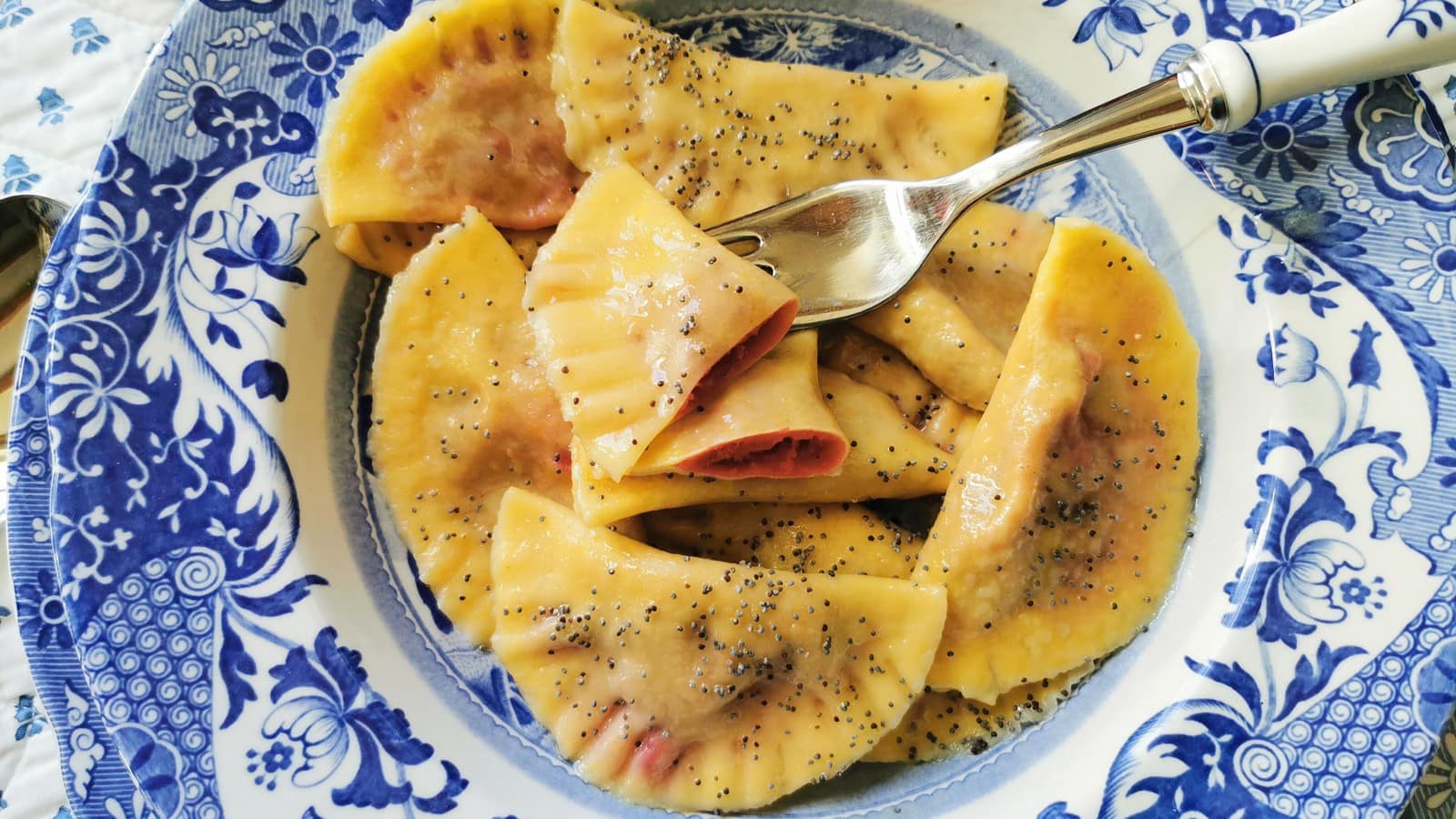 Beet ravioli in blue and white dish.