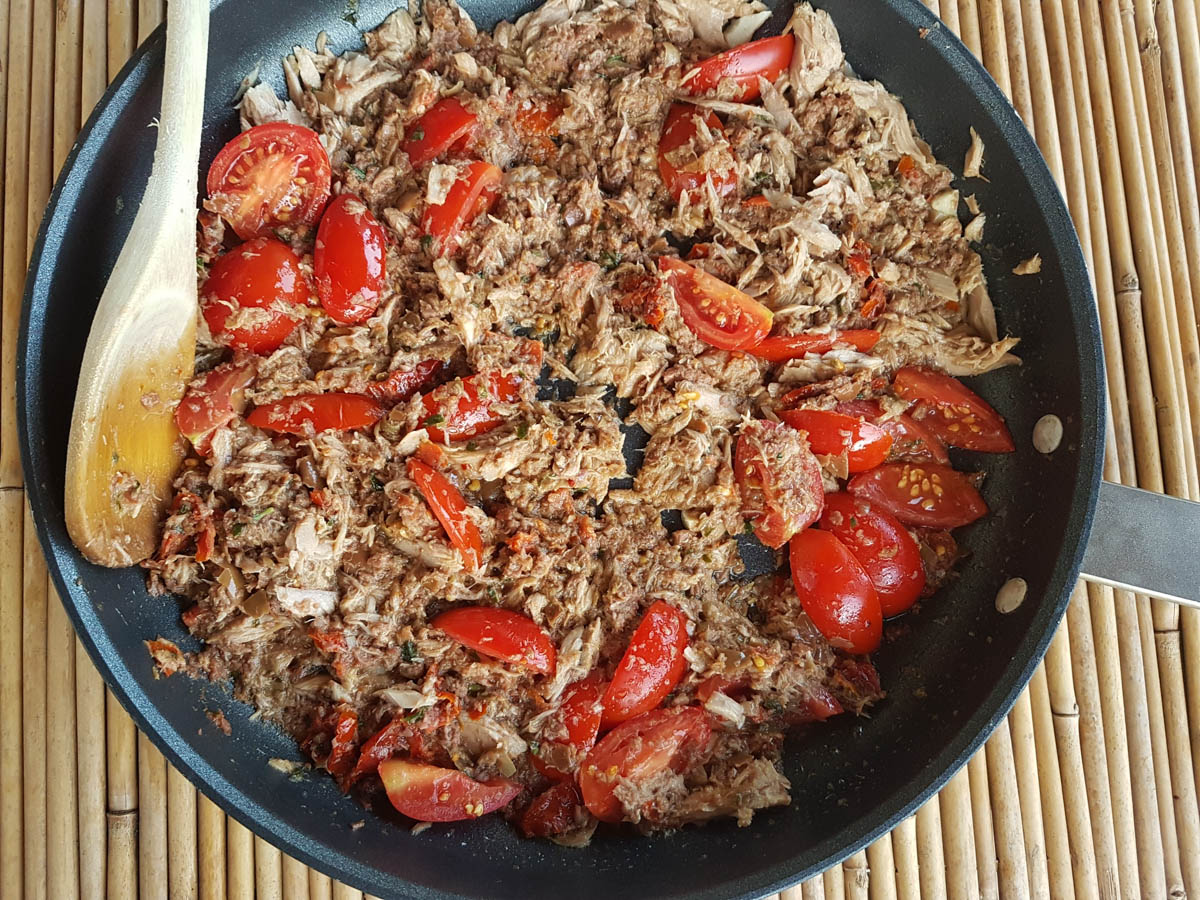 Tomatoes added to the black olive pesto sauce