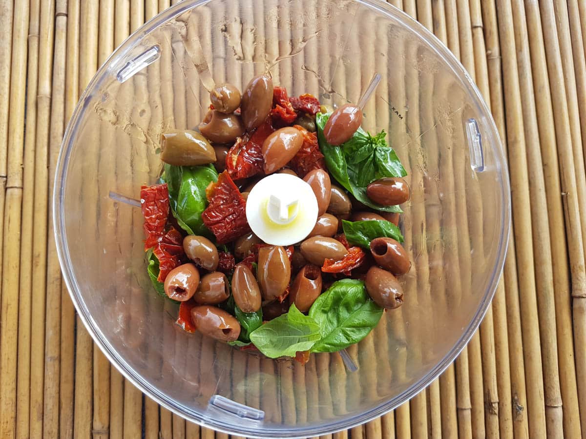 Basi leaves, olives, sun-dried tomatoes and capers in a food processor