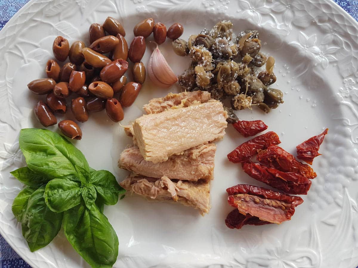 Black olive pesto ingredients portioned on a plate