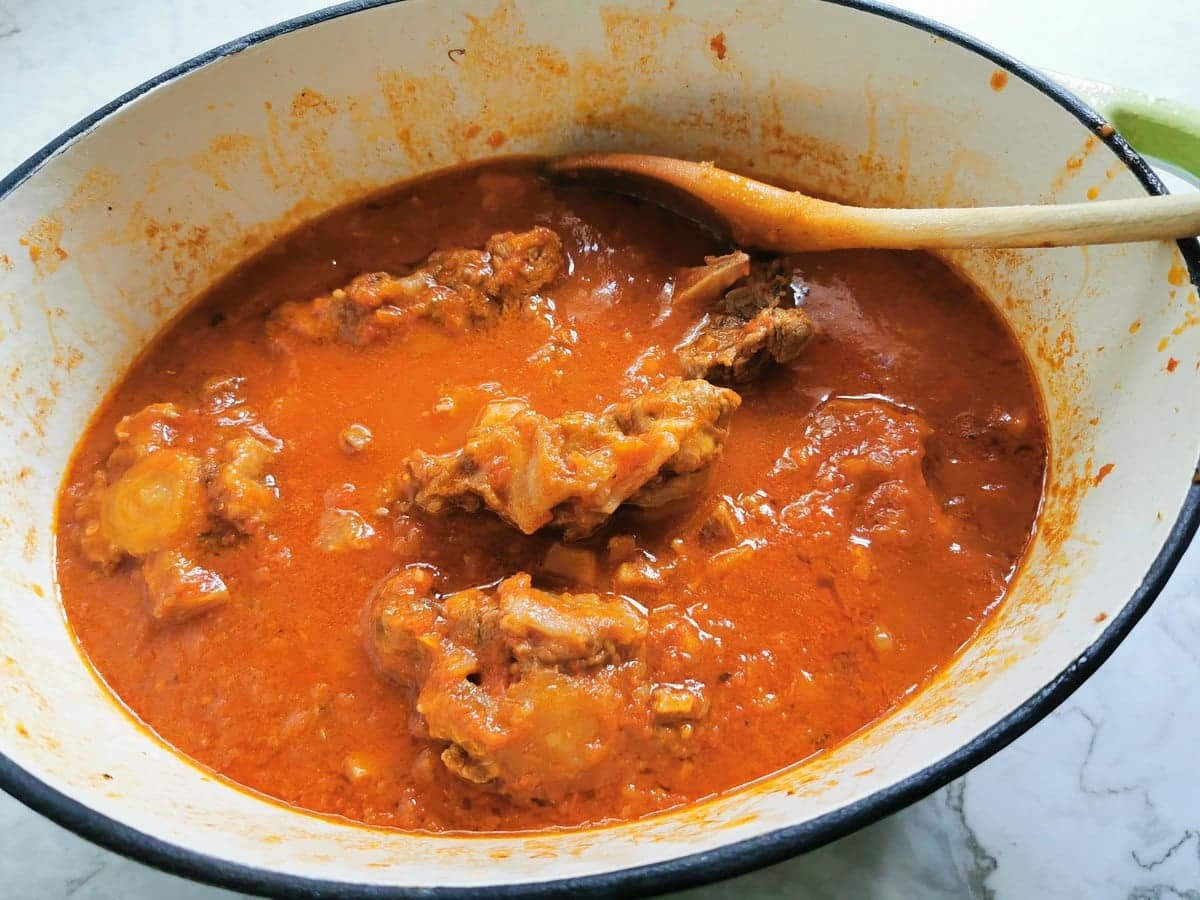 oxtail in tomato sauce in Dutch oven.