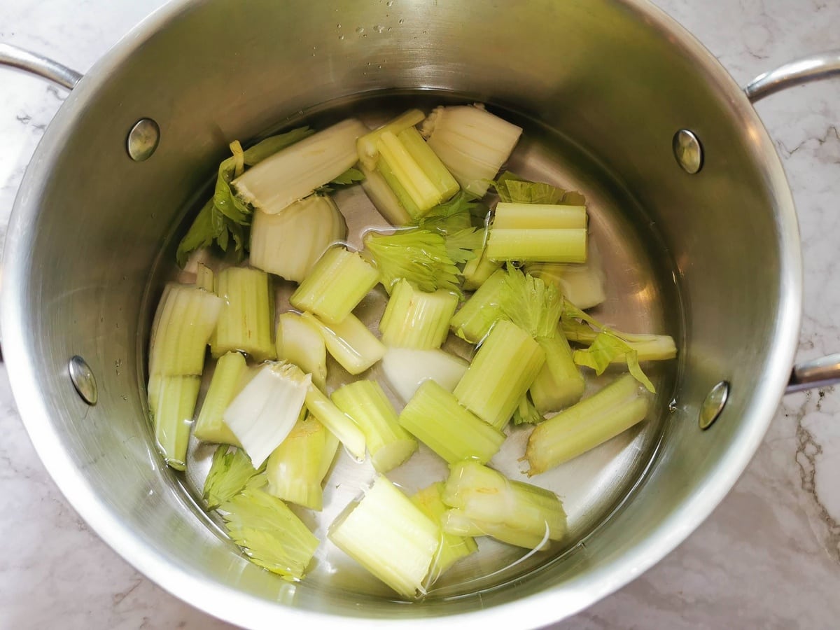 Celery pieces in saucepan with water.