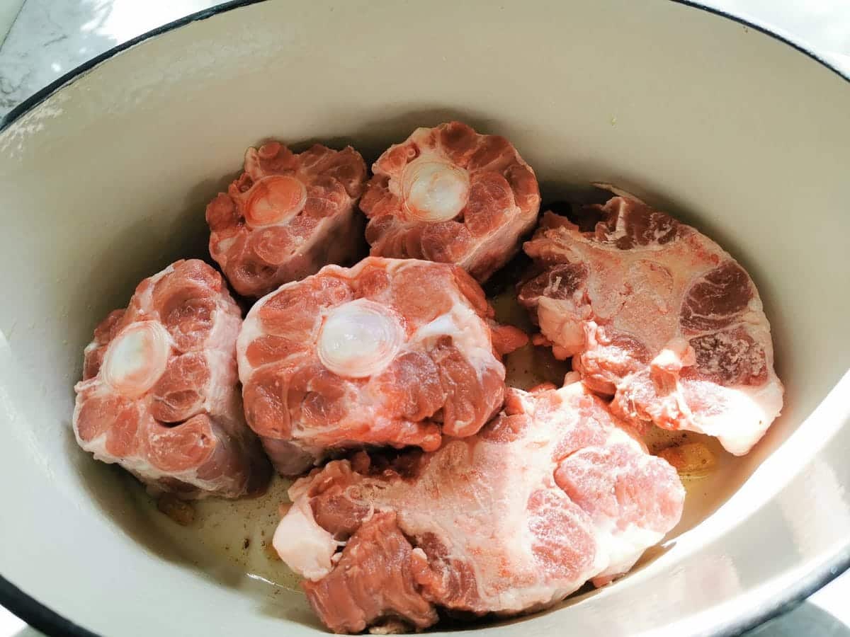 pieces of oxtail in Dutch oven.