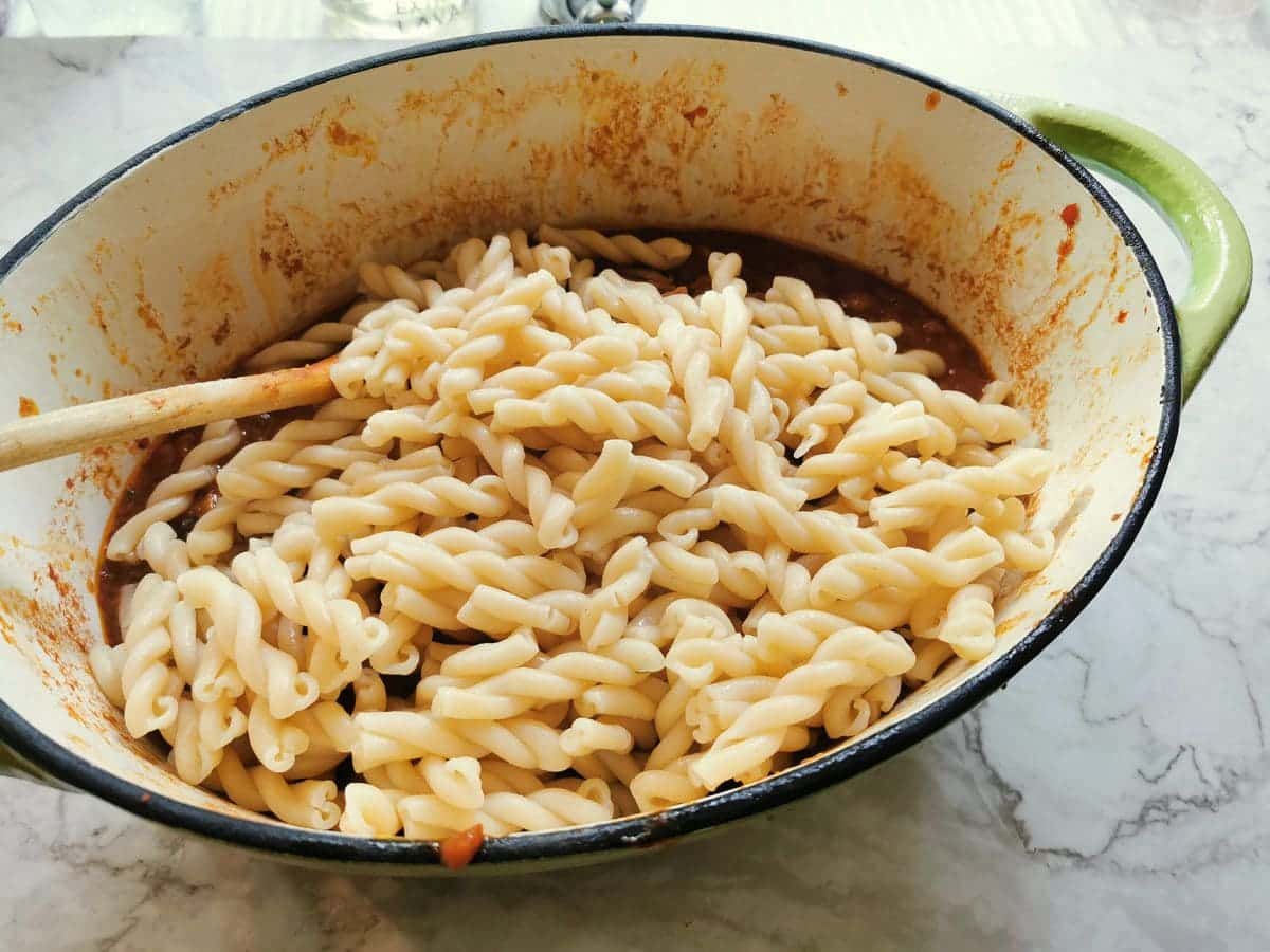 Cooked gemelli pasta in Dutch oven with oxtail ragu