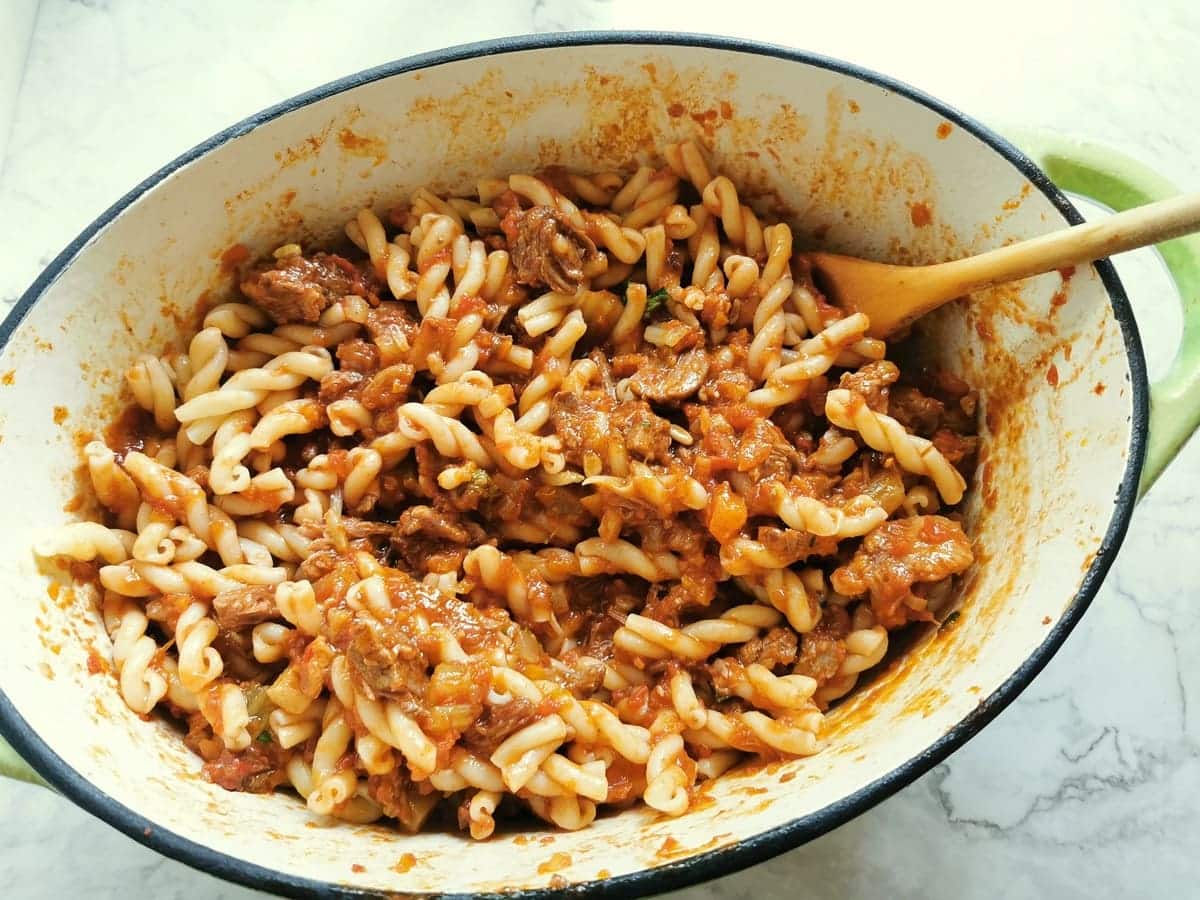 Gemelli pasta and oxtail ragu mixed together in Dutch oven.