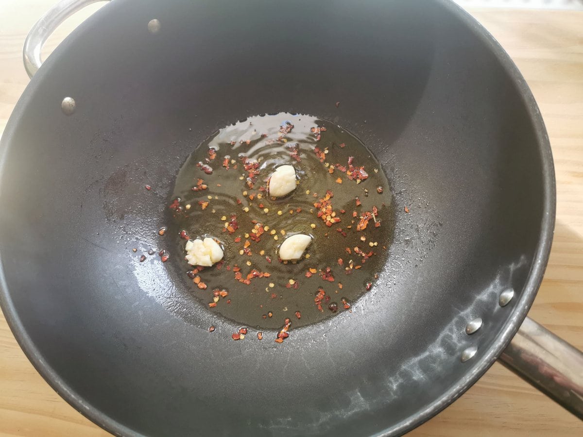 Whole garlic cloves and peperoncino flakes in deep skillet with olive oil.