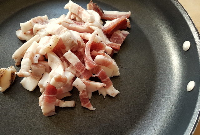 pieces of pork cheek (guanciale) in iron frying pan