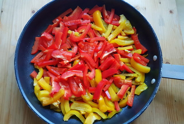 red and yellow bell pepper pieces in frying pan