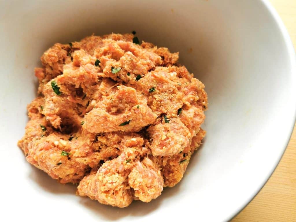 ready raw meatball mixture in white bowl