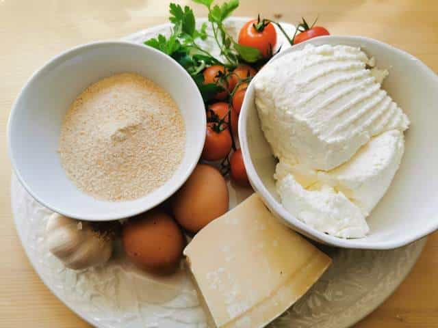 ingredients for ricotta balls in tomato sauce on white plate