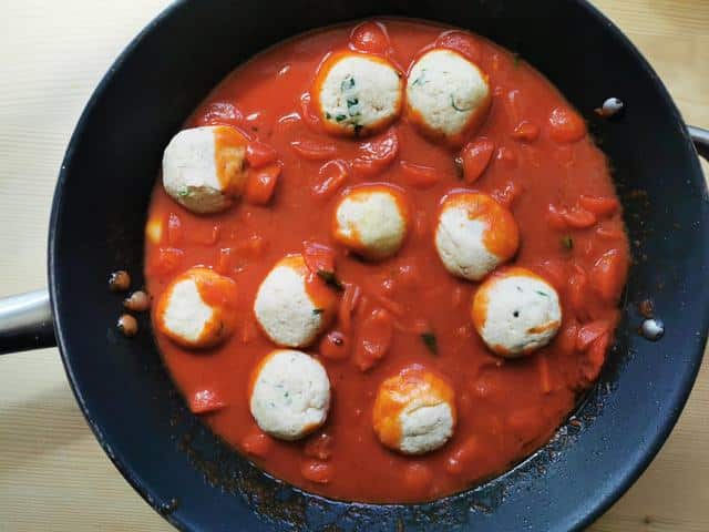 Calabrian ricotta balls cooking in tomato sauce