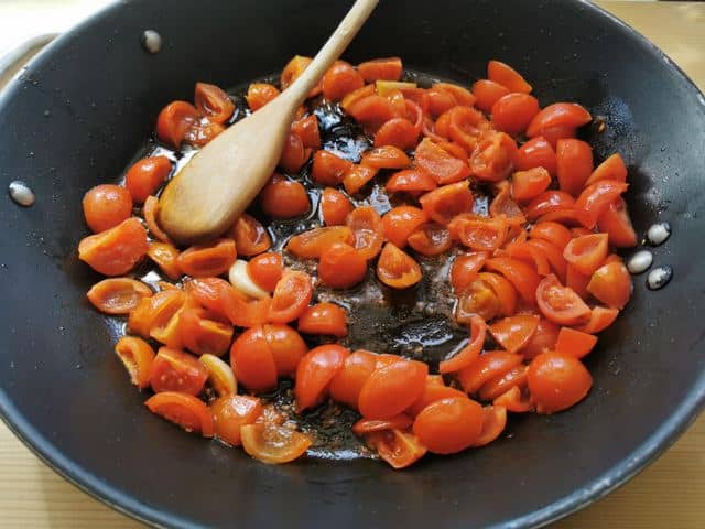 cherry tomatoes cooking in skillet 