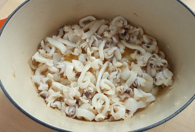 onions and cuttlefish cooking in Dutch oven