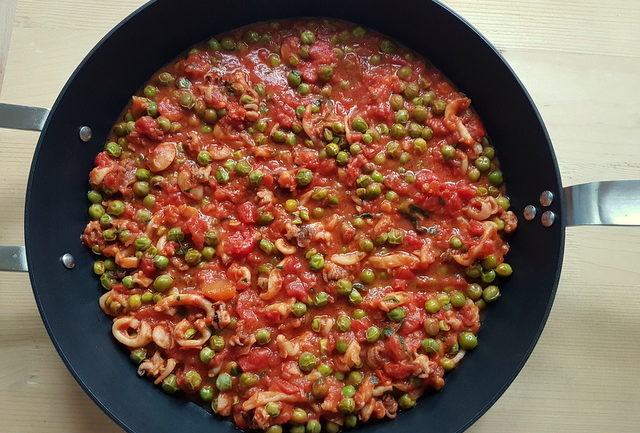 stewed cuttlefish and peas in deep skillet