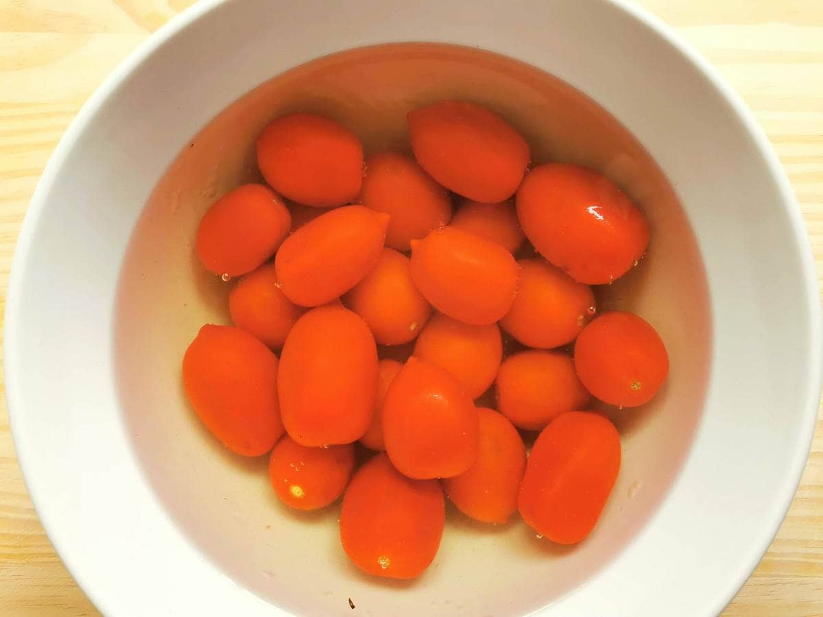tomatoes in boiling water in white bowl
