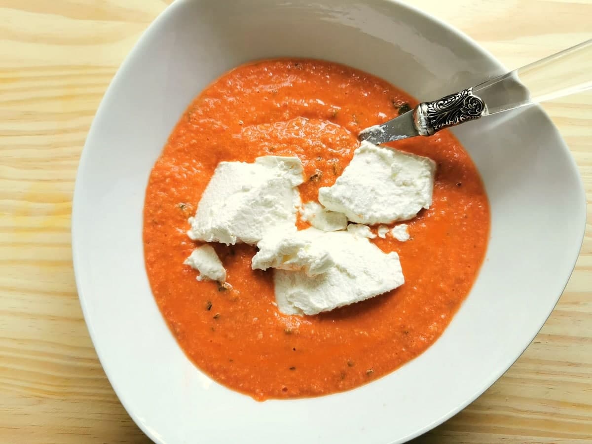 fresh ricotta added to pesto in white bowl