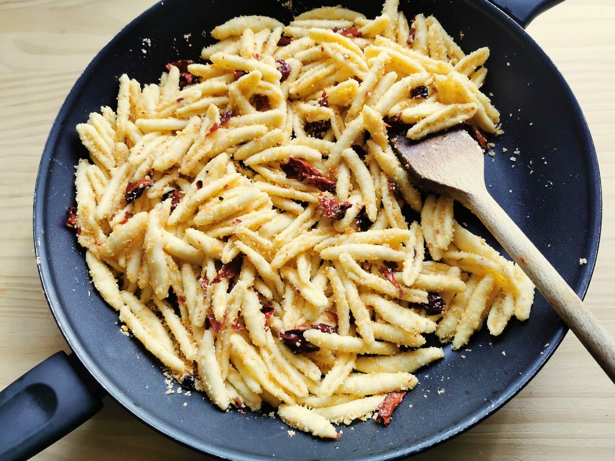 Senise peppers added to the pasta in the pan.