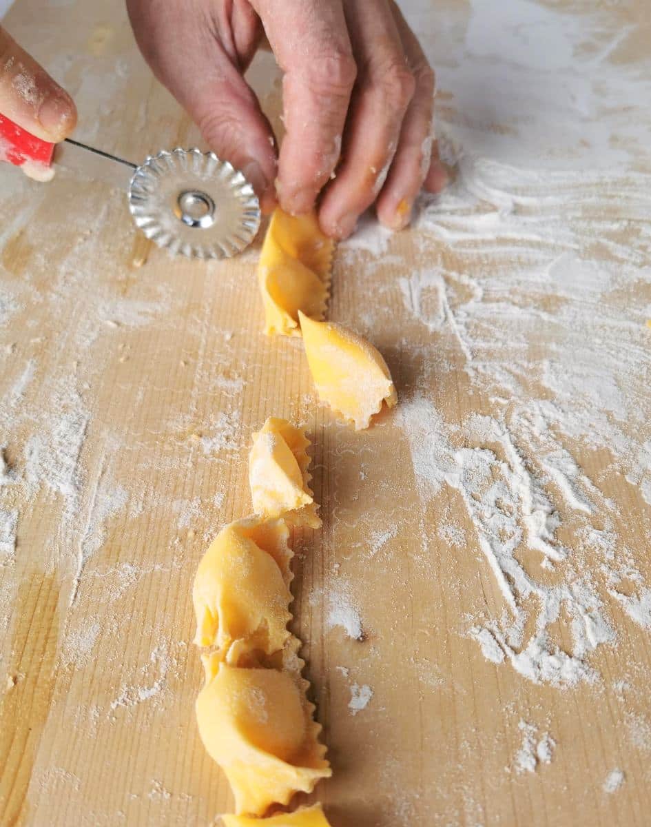 Using a pasta wheel cutter to cut the agnolotti into individual sizes