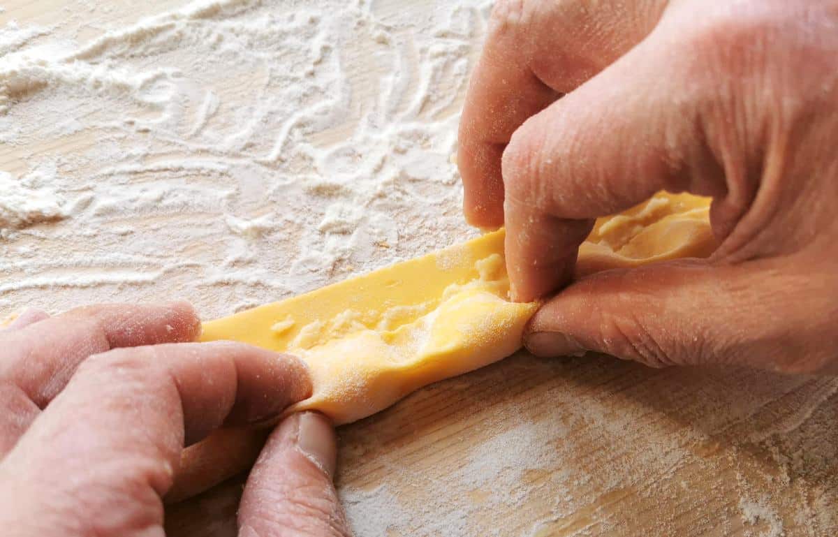 Pinching between each mound of filling to give them the agnolotti their distinctive shape