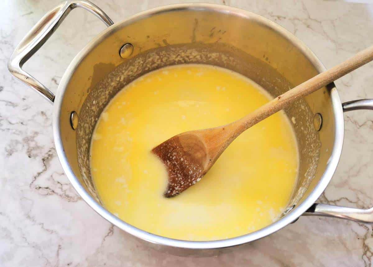 Fontina cheese melted in milk in pan