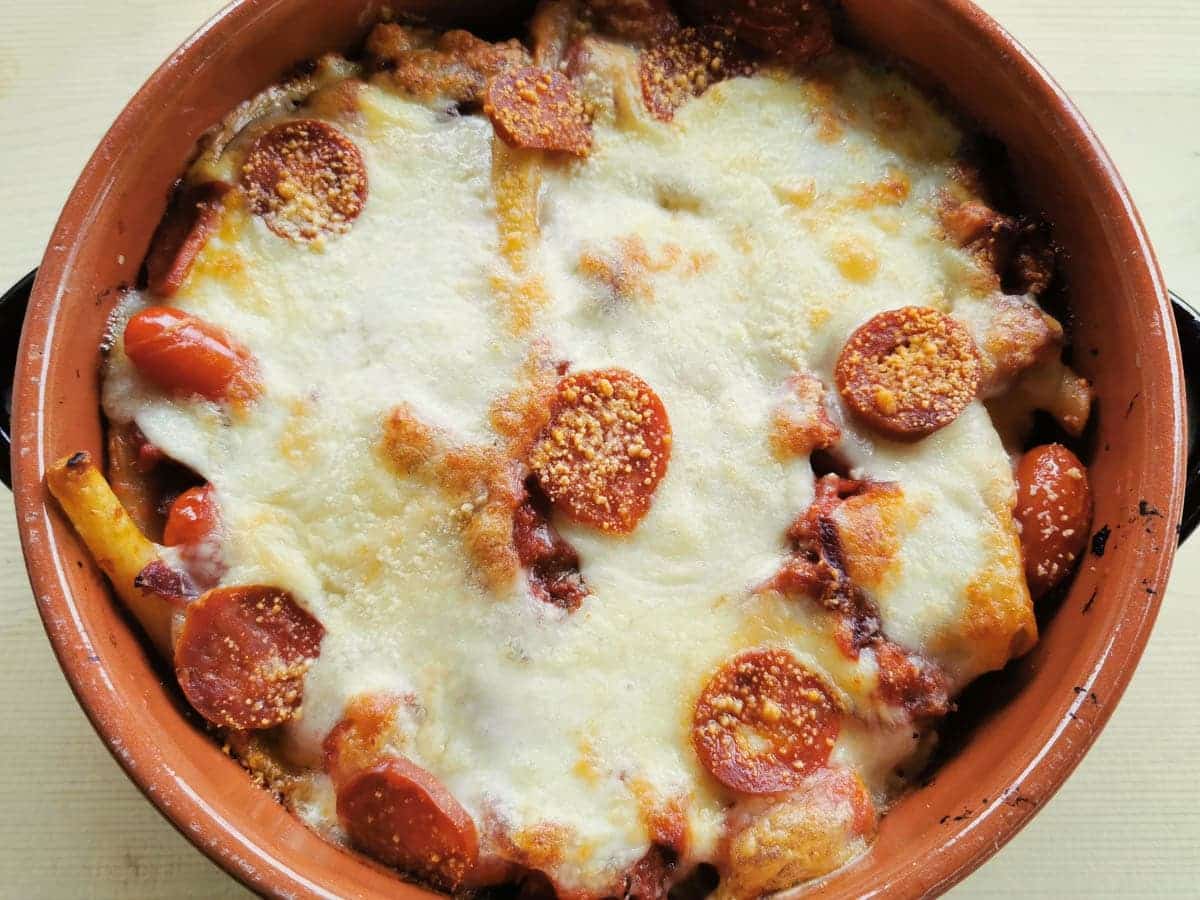 A bowl of baked ziti with spicy sausage.