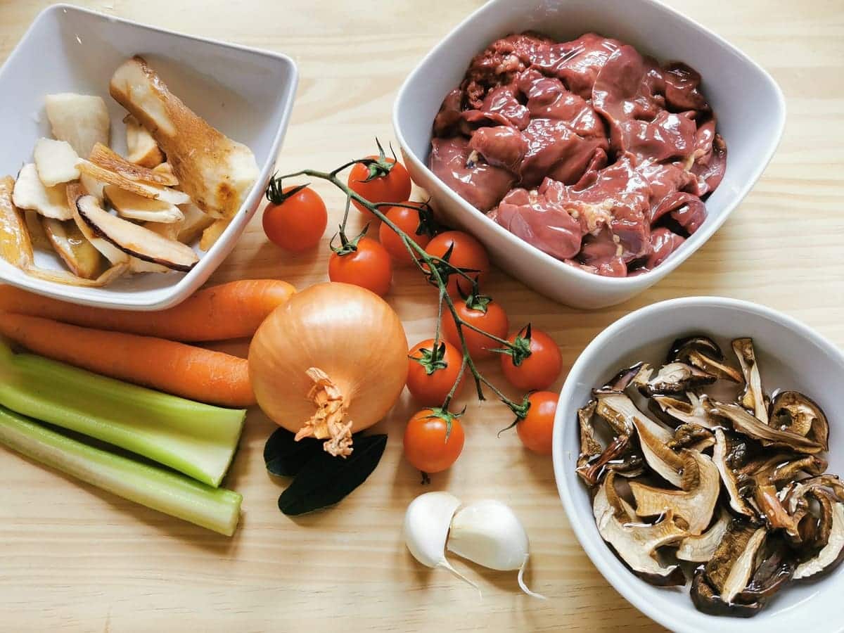 ingredients for chicken liver and porcini ragu on wooden board