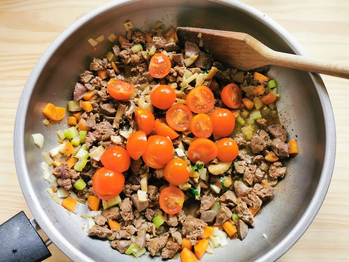 cherry tomatoes added to the chicken livers, mushrooms and vegetables in deep frying pan