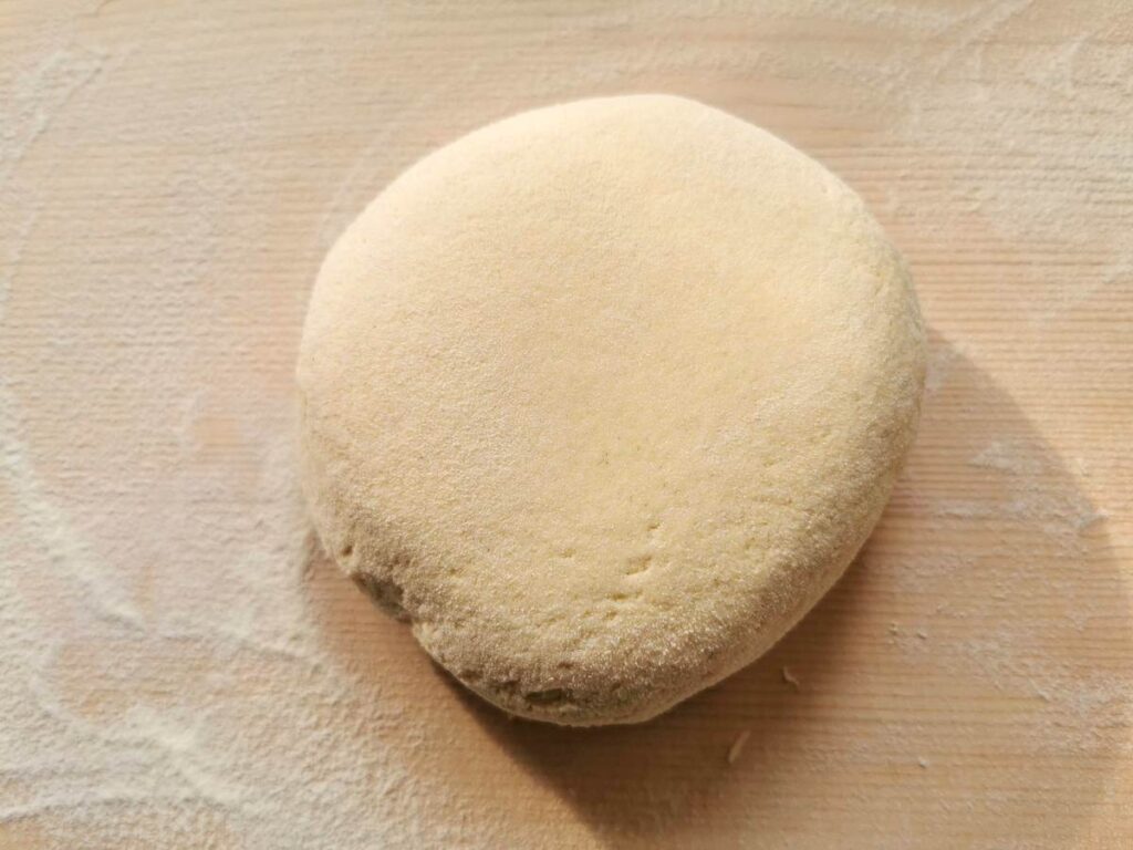 Ball of corn and wheat flour pasta dough on wooden board