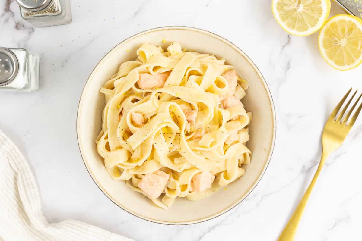 Creamy salmon pasta in a bowl with a fork.