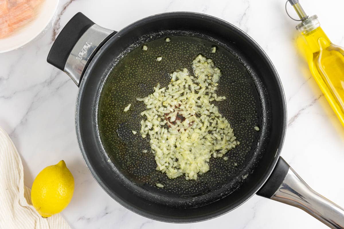 Onions being cooked in a deep sauté pan with butter and extra virgin olive oil.