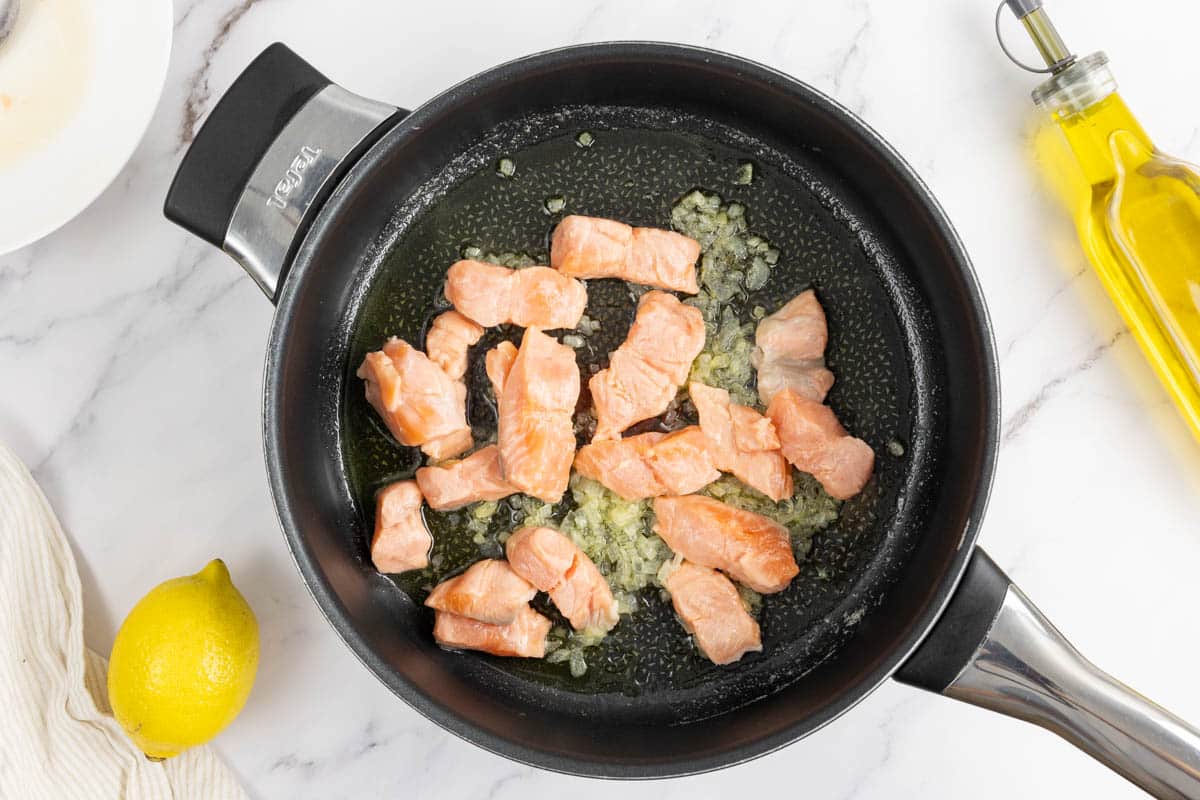 Salmon being cooked with the onions.