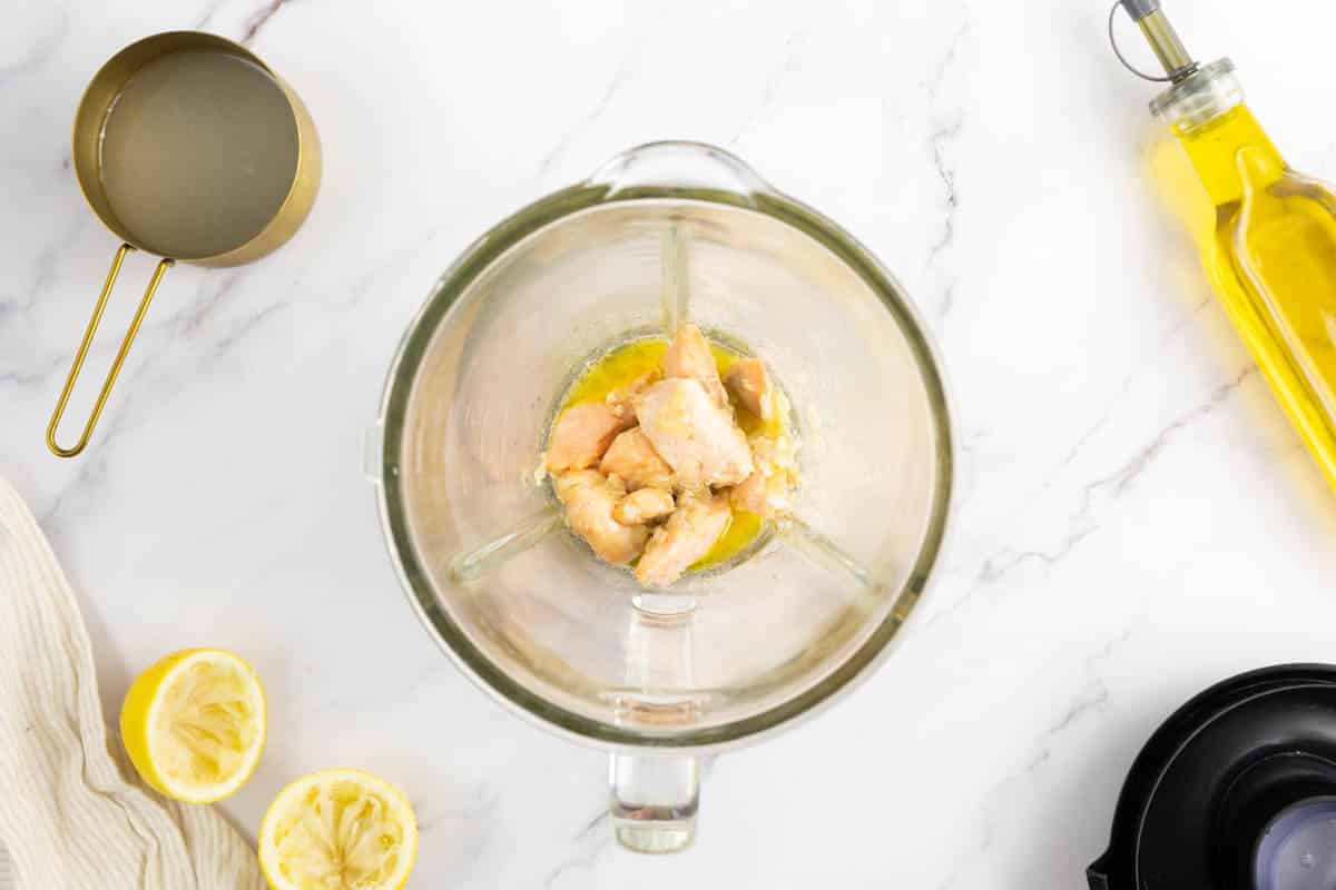 Salmon, onion and the oil emulsion being blended in a blender.