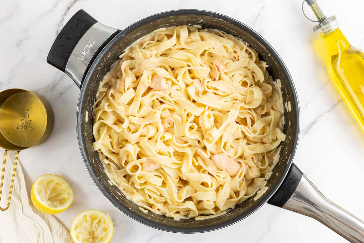 Pasta and salmon chunks with the creamy lemon sauce in the deep sauté pan.