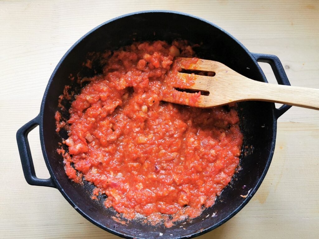 pancetta, onion and tomato sauce cooking in skillet