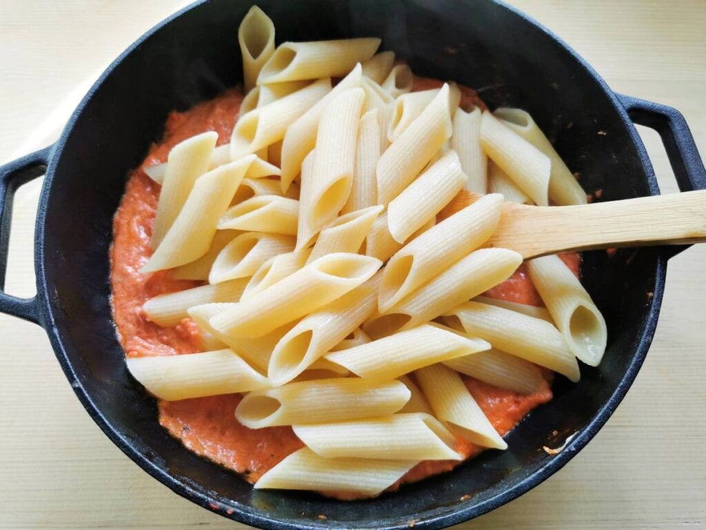 cooked giant penne added to the pancetta sauce in skillet