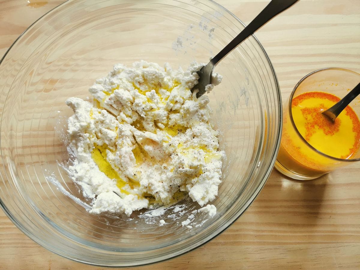 Creamed ricotta with olive oil in glass bowl and saffron powder in a glass of milk.